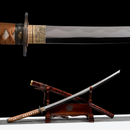 Rurouni Kenshin Katana with brown handle and intricate gold guard on black stand, sheath with red designs, blade shown close-up.