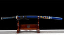 Blue and gold dragon-adorned katana on wooden stand against a black background, intricate handle details. Aoi Ryu Katana.