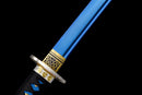 Close-up of a katana with a blue blade, gold and black geometric guard, and black handle with blue accents. Aoi Ryū Katana.