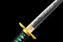 Golden tsuba and black-green handle of a Katana with the blade featuring engraved patterns on a black background. Tokito Muichiro Katana.