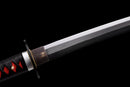 Close-up of the Tanjiro Katana, showing a polished silver blade, black guard, and red handle wrap with black accents. Tanjiro Katana.